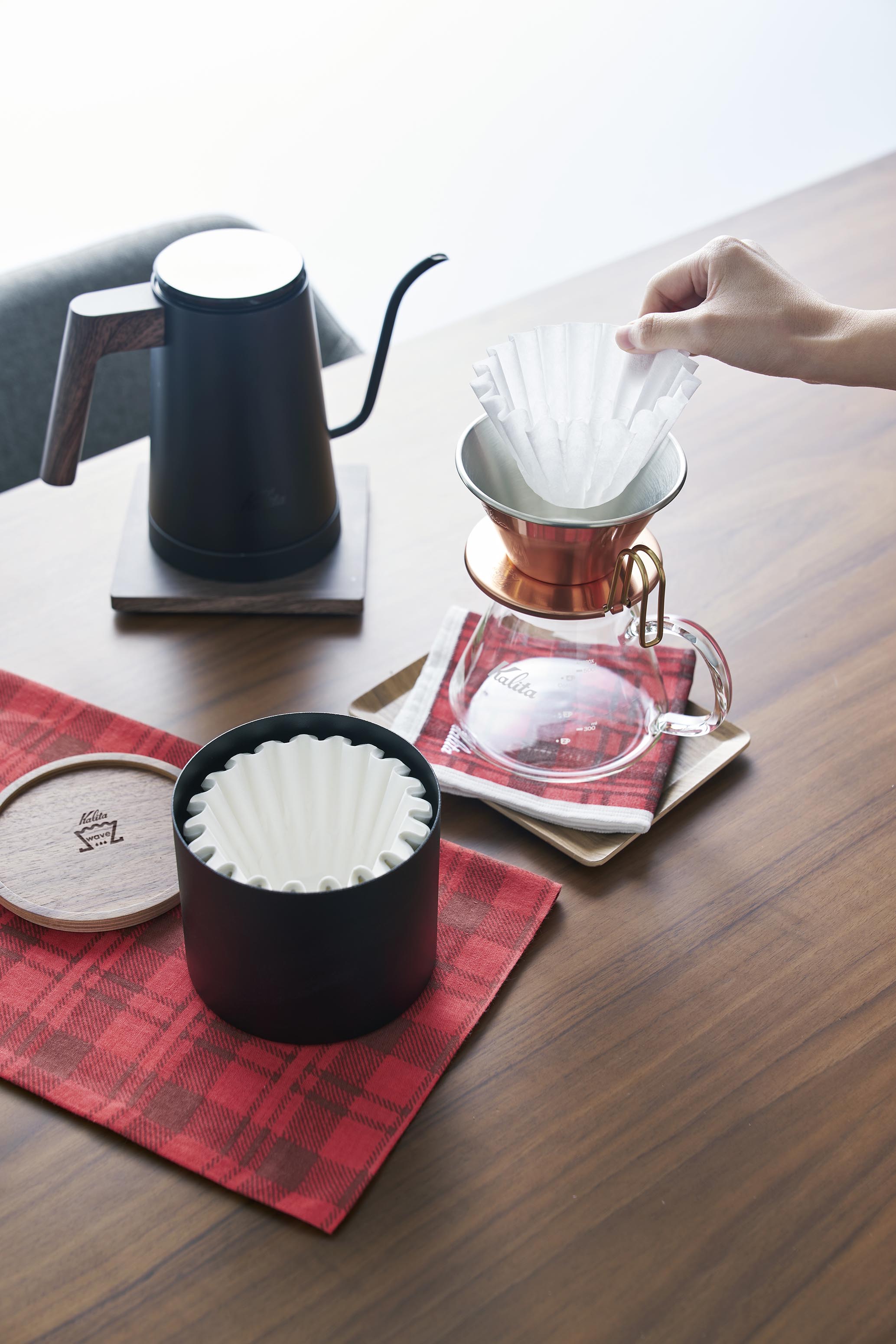 開いたケースとドリッパーを近くに置いた使用場面。ケトル・サーバー等を含む器具一式の販売写真ではありません。写真:カリタ。